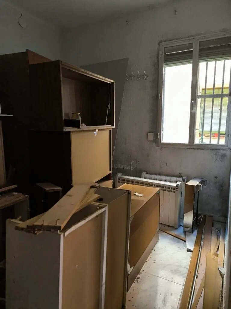 Interior deteriorado del piso de Legazpi antes de la reforma, con muebles rotos, humedad y suciedad