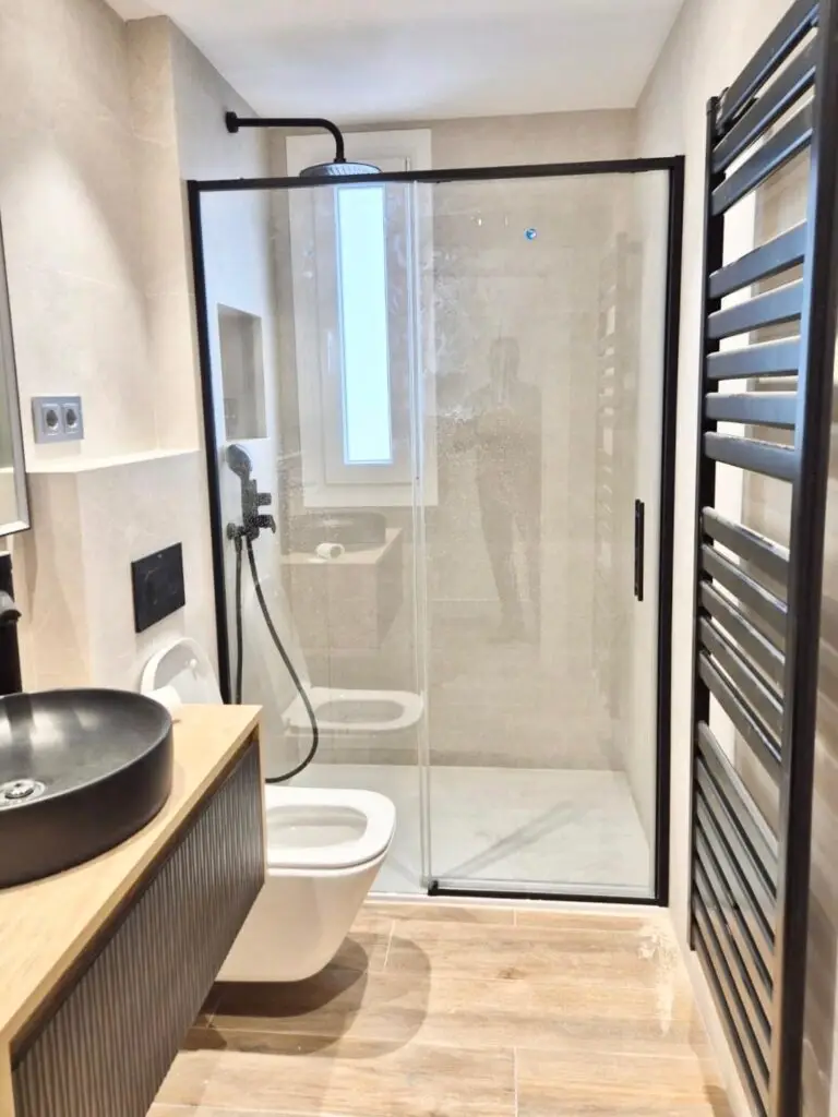 Baño reformado con ducha y acabados en tonos neutros en el Barrio de Salamanca, Madrid