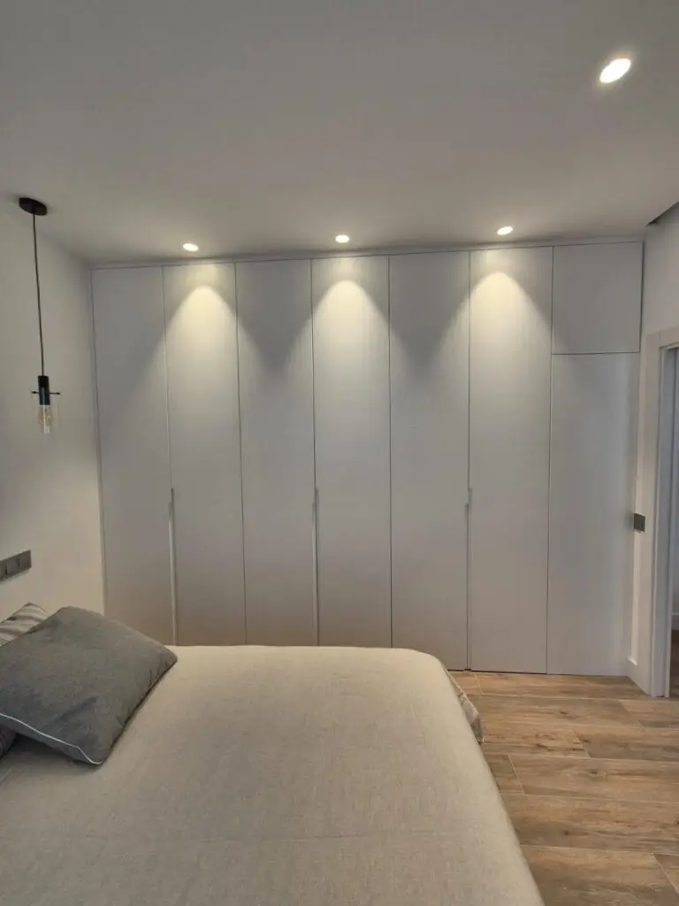 Dormitorio con frente de armario a medida tras la reforma de una vivienda en el Barrio de Salamanca, Madrid