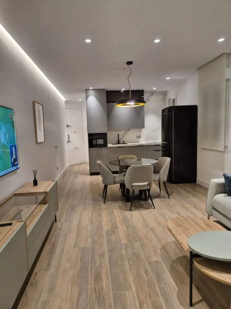 Salón, comedor y cocina diáfanos tras la reforma de una vivienda en el Barrio de Salamanca, Madrid