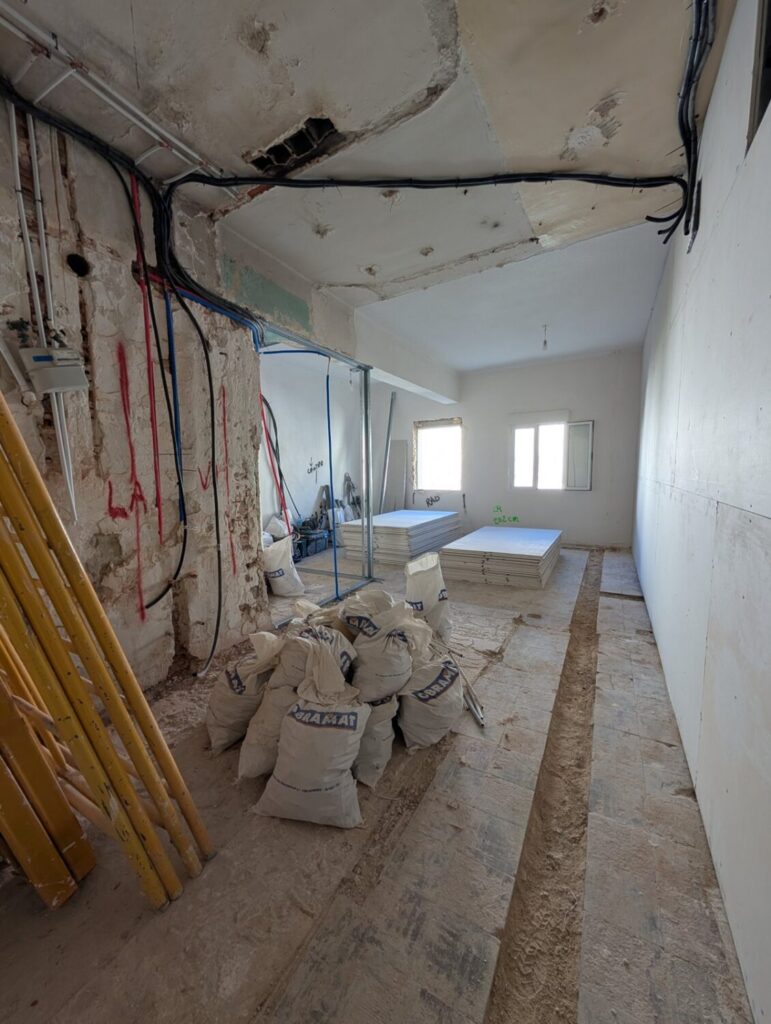 Piso del barrio de Comillas, en Carabanchel, durante la obra: tabiques retirados e instalaciones a la vista antes de la nueva declaración responsable