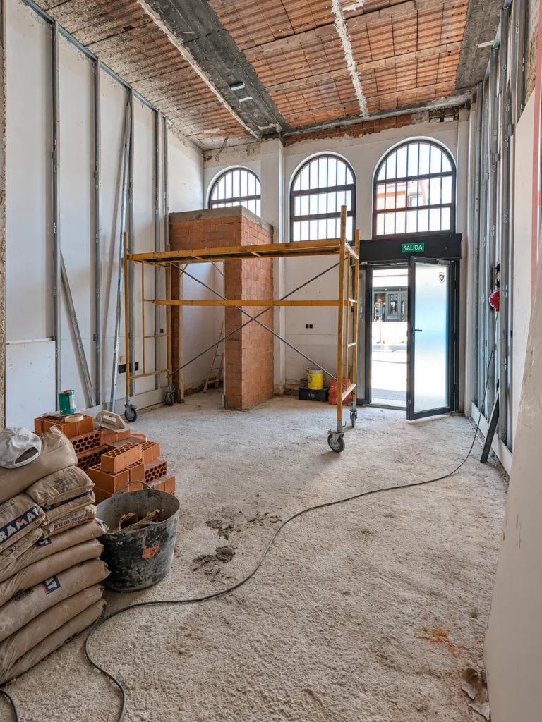 Local en obra con el suelo levantado y las ventanas en arco al fondo